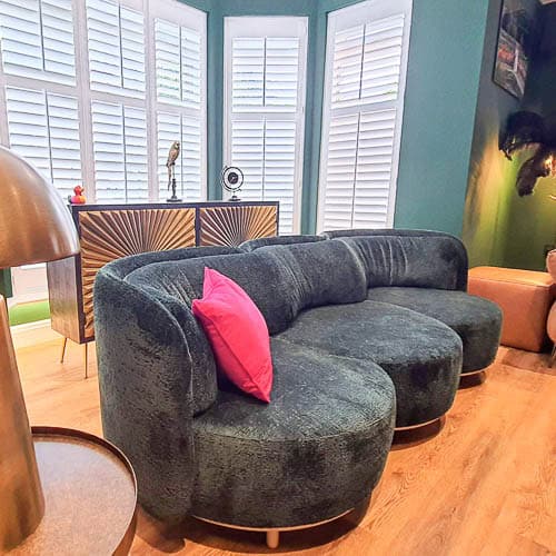 Modern lounge with a curved velvet sofa and bold, cosy styling by Hertfordshire interior designer Farr Better Interiors